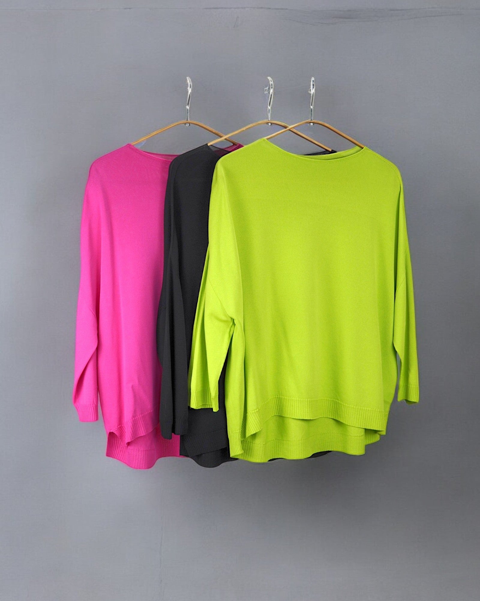 Trei bluze largi în culori vibrante: roz, negru și verde neon, din material lejer.
