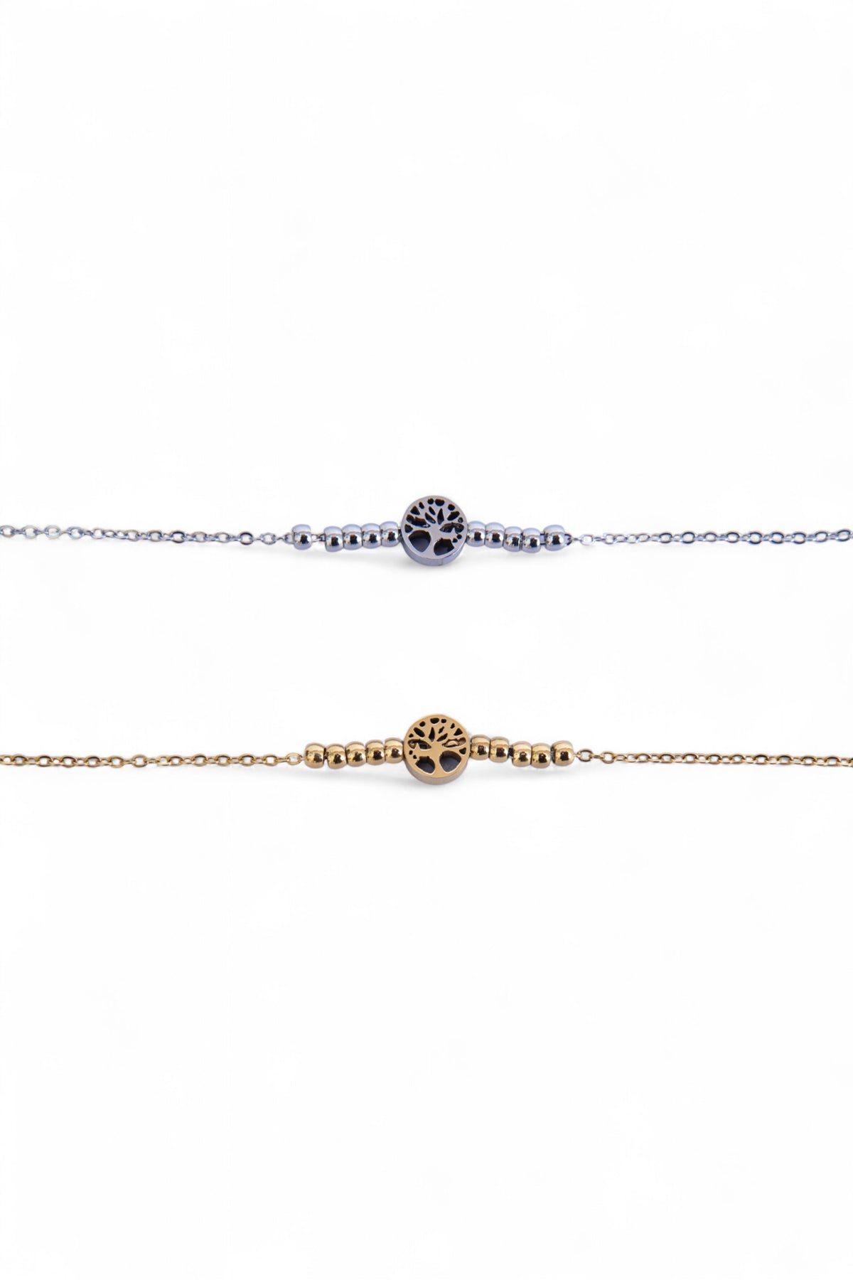 Două brățări subțiri din oțel inoxidabil, una argintie și una aurie, cu simbol Arborele Vieții și biluțe metalice, fotografiate în detaliu pe fundal alb.