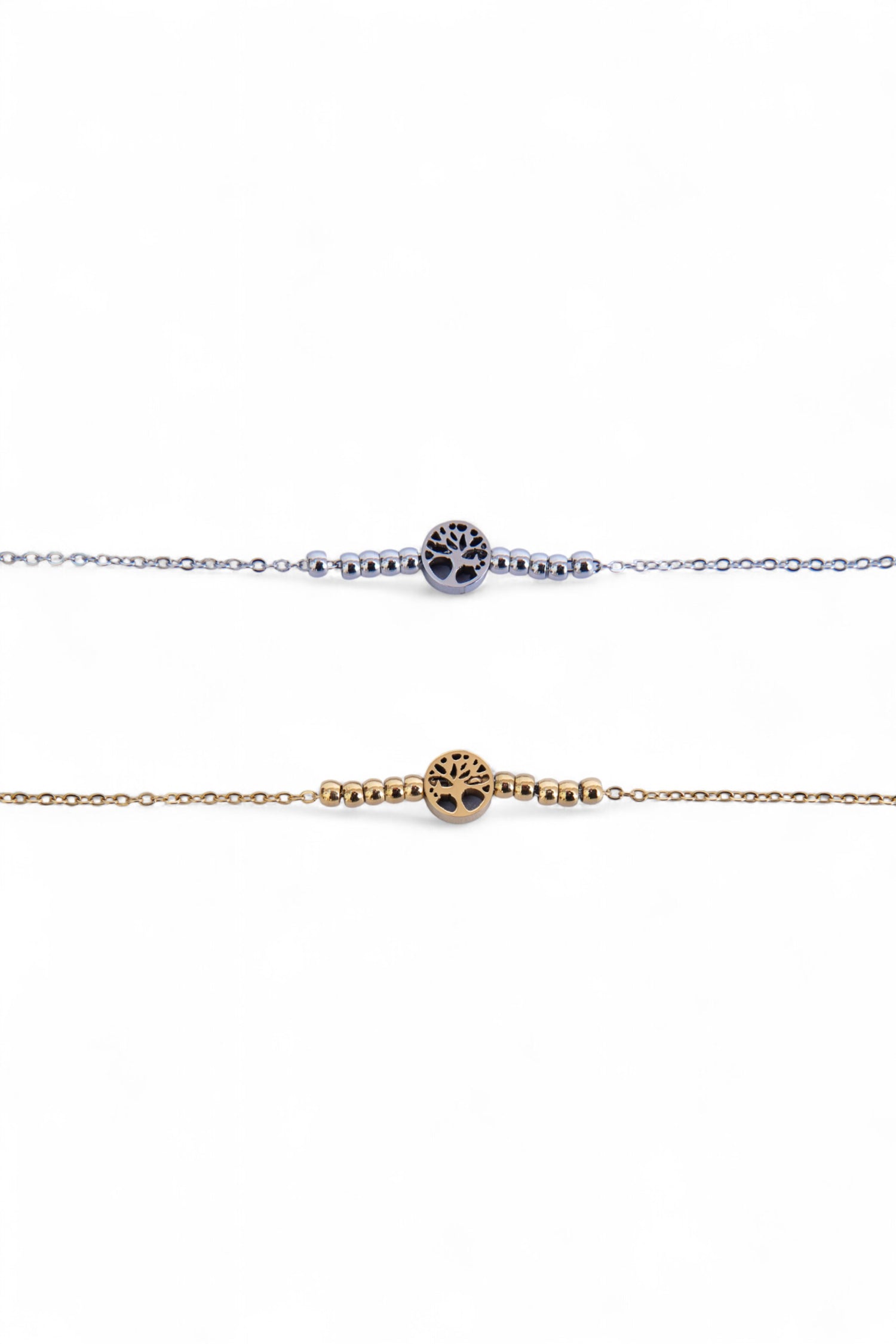 Două brățări subțiri din oțel inoxidabil, una argintie și una aurie, cu simbol Arborele Vieții și biluțe metalice, fotografiate în detaliu pe fundal alb.