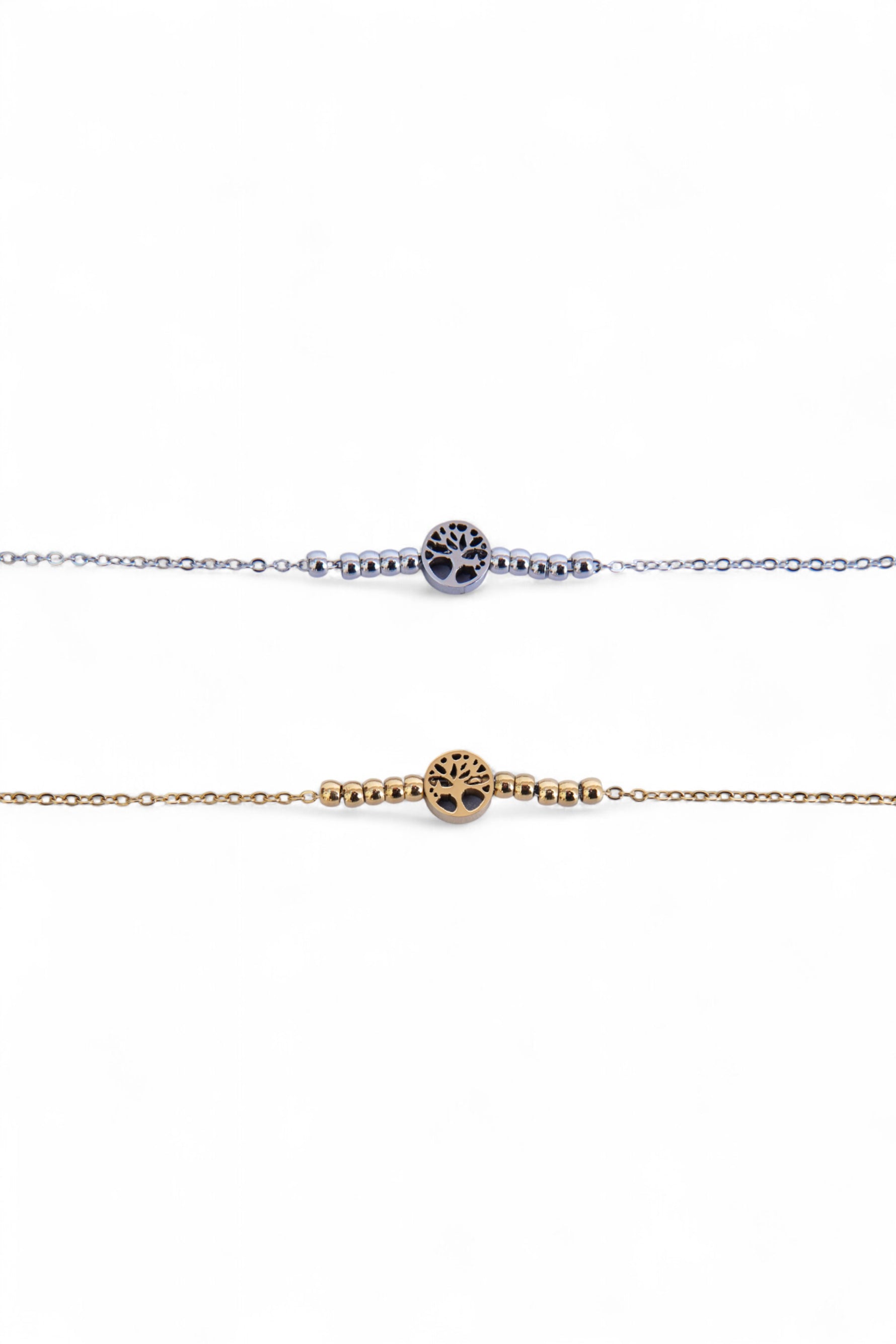 Două brățări subțiri din oțel inoxidabil, una argintie și una aurie, cu simbol Arborele Vieții și biluțe metalice, fotografiate în detaliu pe fundal alb.