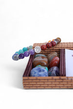 Brățară elastică cu cristale naturale multicolore, asociate chakrelor, fotografiată din apropiere.