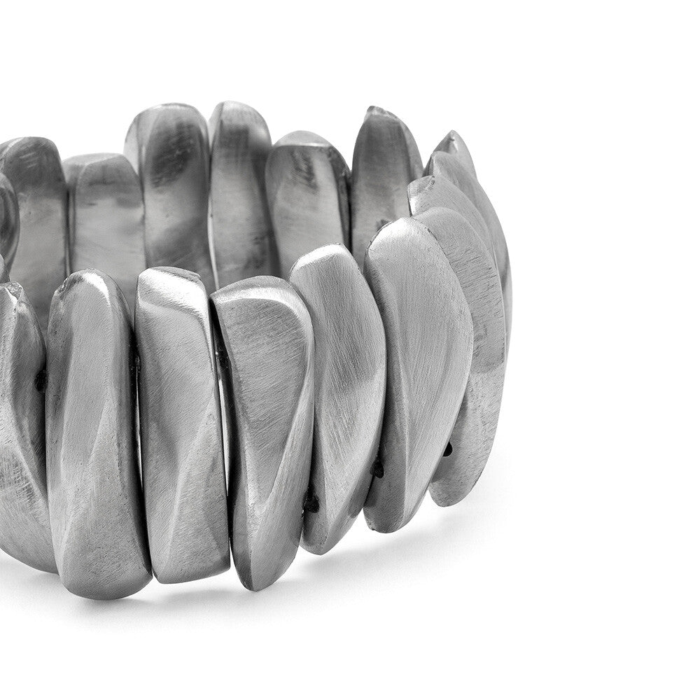 Detaliu lateral al brățării elastice din aluminiu reciclat, cu elemente sculpturale argintii dispuse compact.