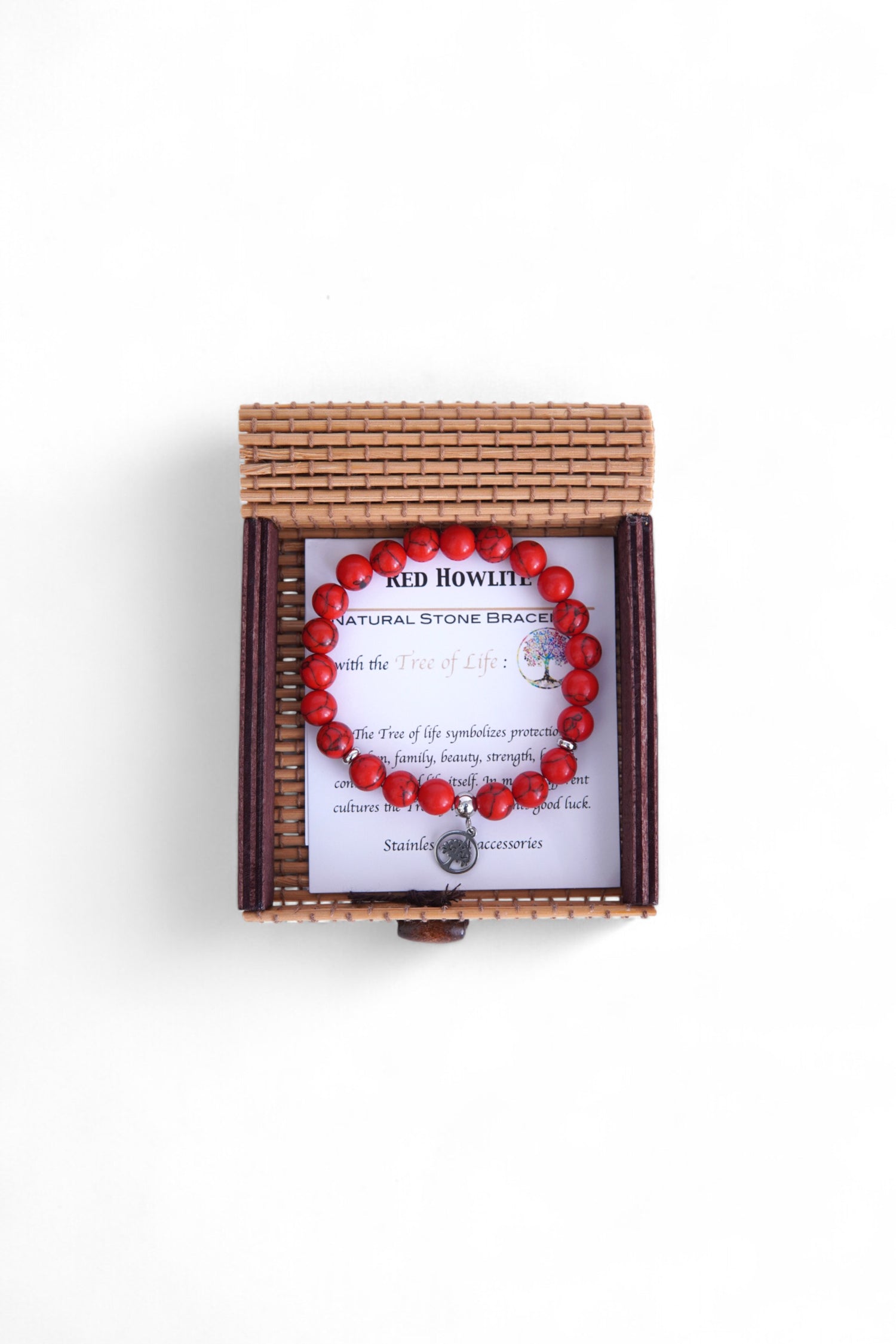 Brățară din howlit roșu, prezentată într-o cutie împletită din bambus, pe fundal alb.