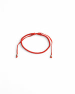  Brățară minimalistă din șnur roșu reglabil, accesorizată cu biluțe aurii.