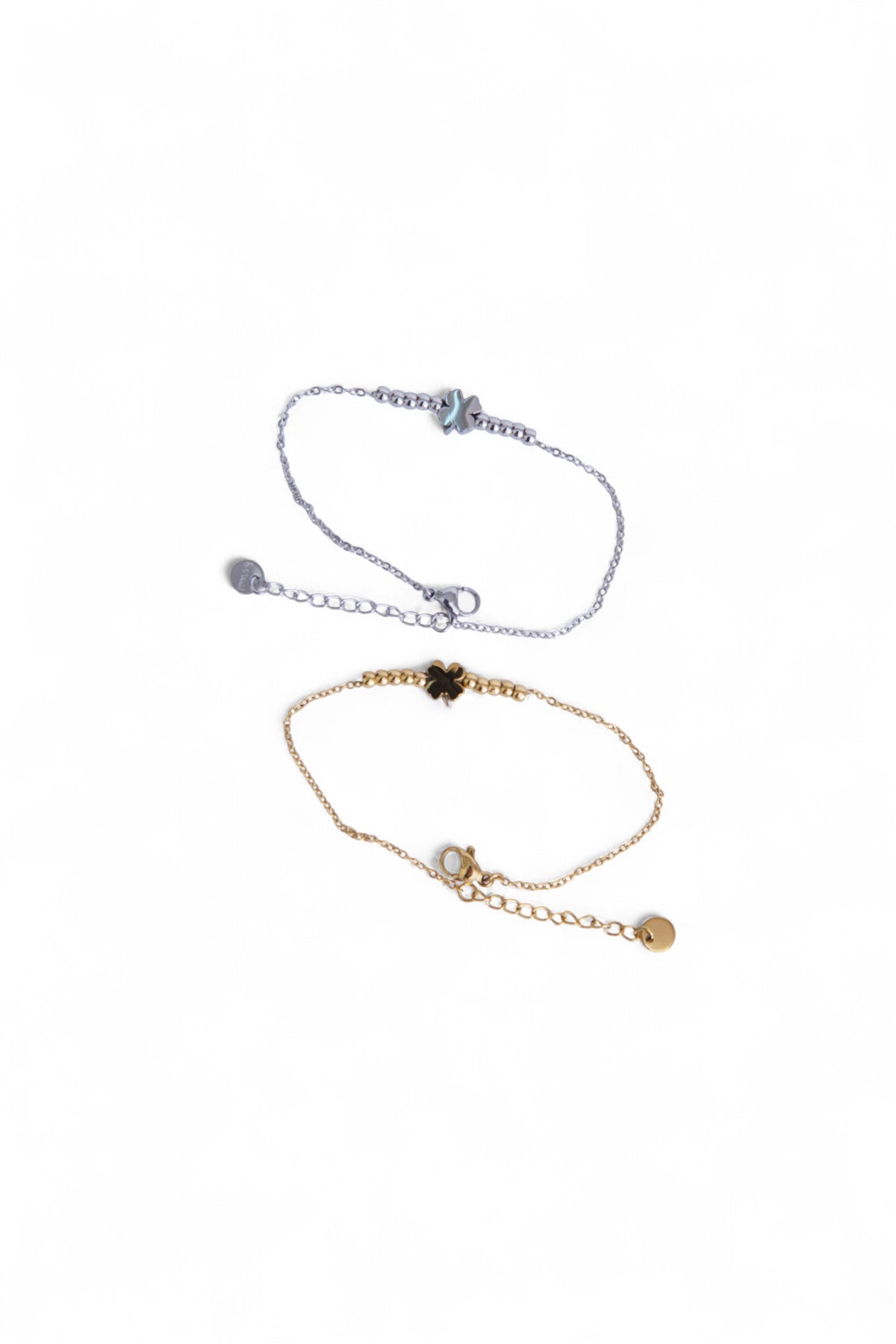 Două brățări cu trifoi, una aurie și una argintie, realizate din oțel inoxidabil, prezentate împreună.