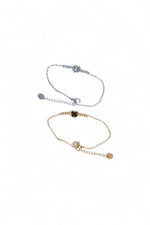 Două brățări cu trifoi, una aurie și una argintie, realizate din oțel inoxidabil, prezentate împreună.