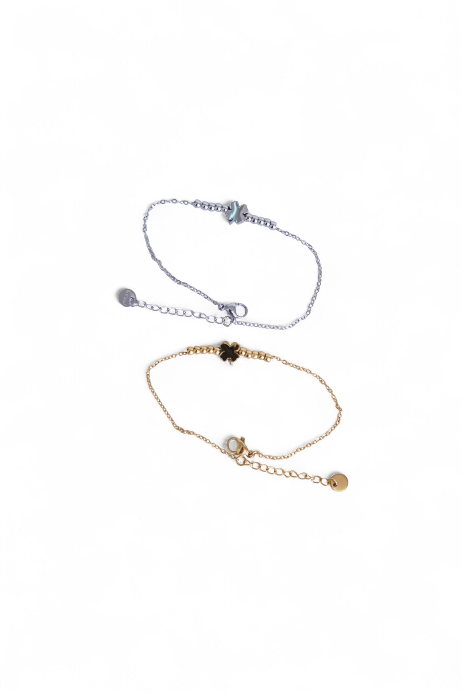 Două brățări cu trifoi, una aurie și una argintie, realizate din oțel inoxidabil, prezentate împreună.