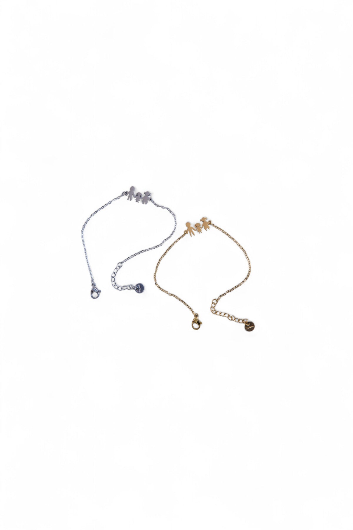 Set de două brățări cu simbol familie, una aurie și una argintie, fotografiate împreună.