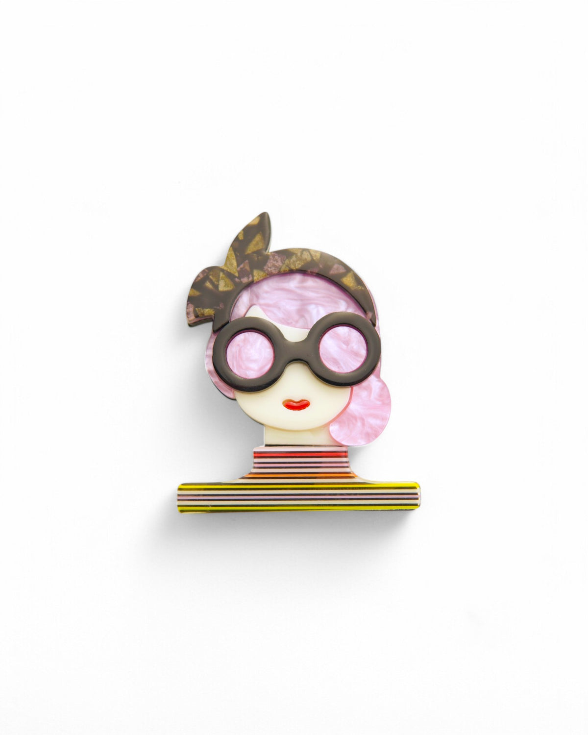 Broșă stilizată cu chip de femeie fashionistă, păr roz perlat, ochelari mari și bentiță decorativă.