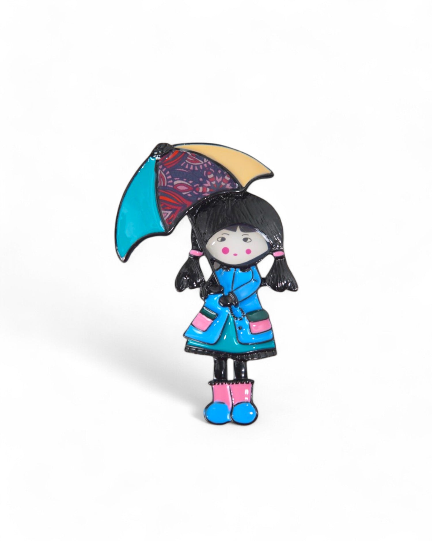 Broșă cu o fetiță în haină albastră, având o umbrelă viu colorată, perfectă pentru un look jucăuș.