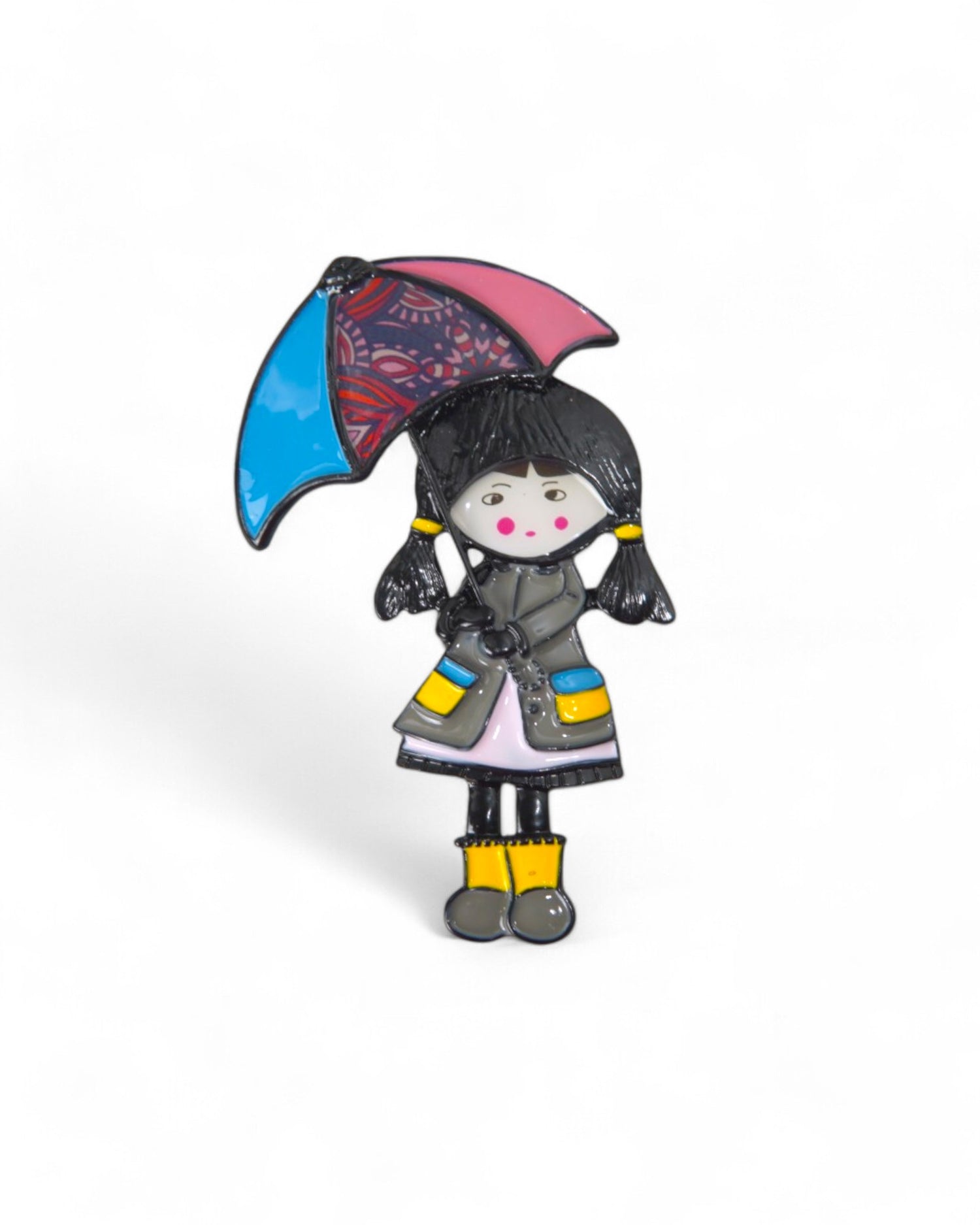Broșă elegantă cu o fetiță în haină gri și cizme galbene, protejată de o umbrelă cu model interesant.