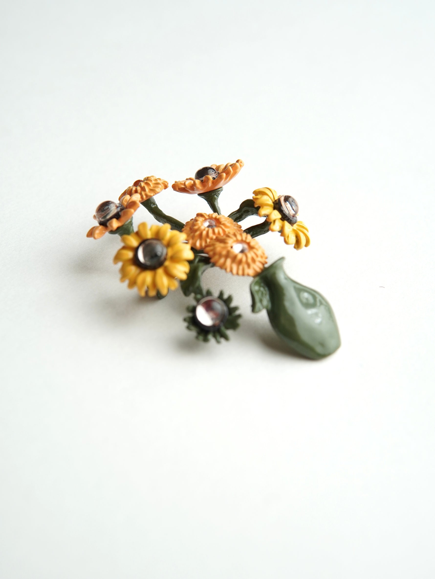 Brosă decorativă în formă de vază cu flori galbene, design artistic cu detalii florale și finisaj delicat.