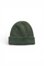 Căciulă tricotată verde închis, cu aspect pufos și croială clasică, ușor de integrat în garderoba de sezon.