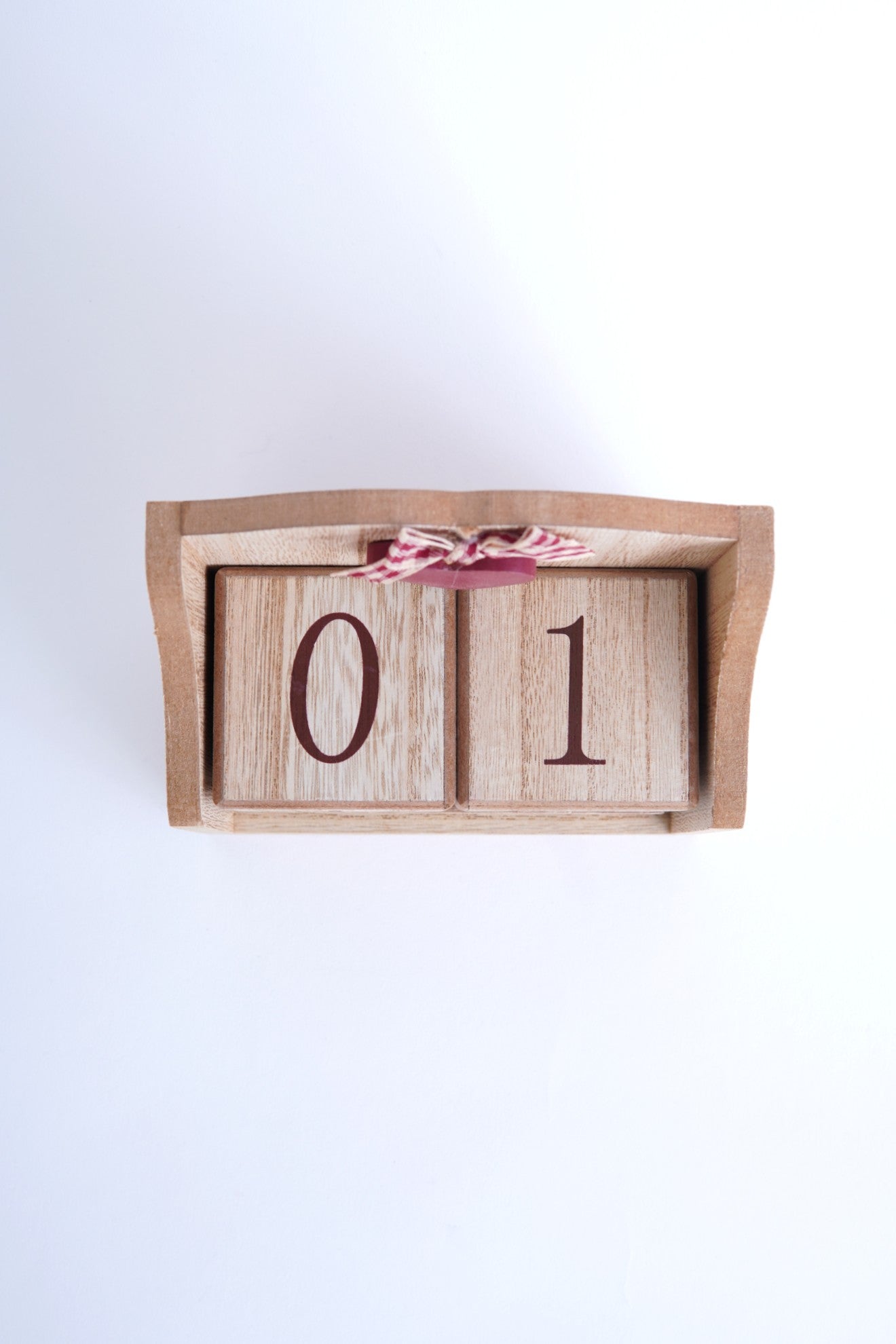 Calendar din lemn văzut de sus, cu două cuburi numerotate 0 și 1, așezate în suportul dreptunghiular, decorat cu inimă roșie și fundiță.
