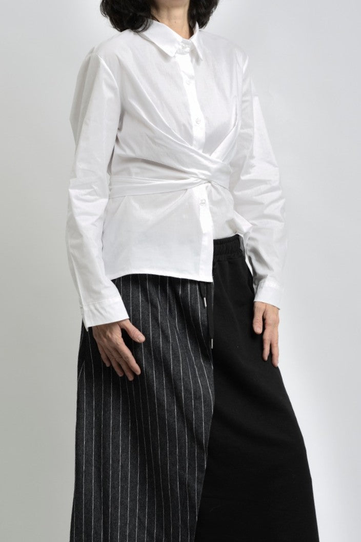 Vedere laterală cămașă albă cu design petrecut și talie marcată, stil modern.