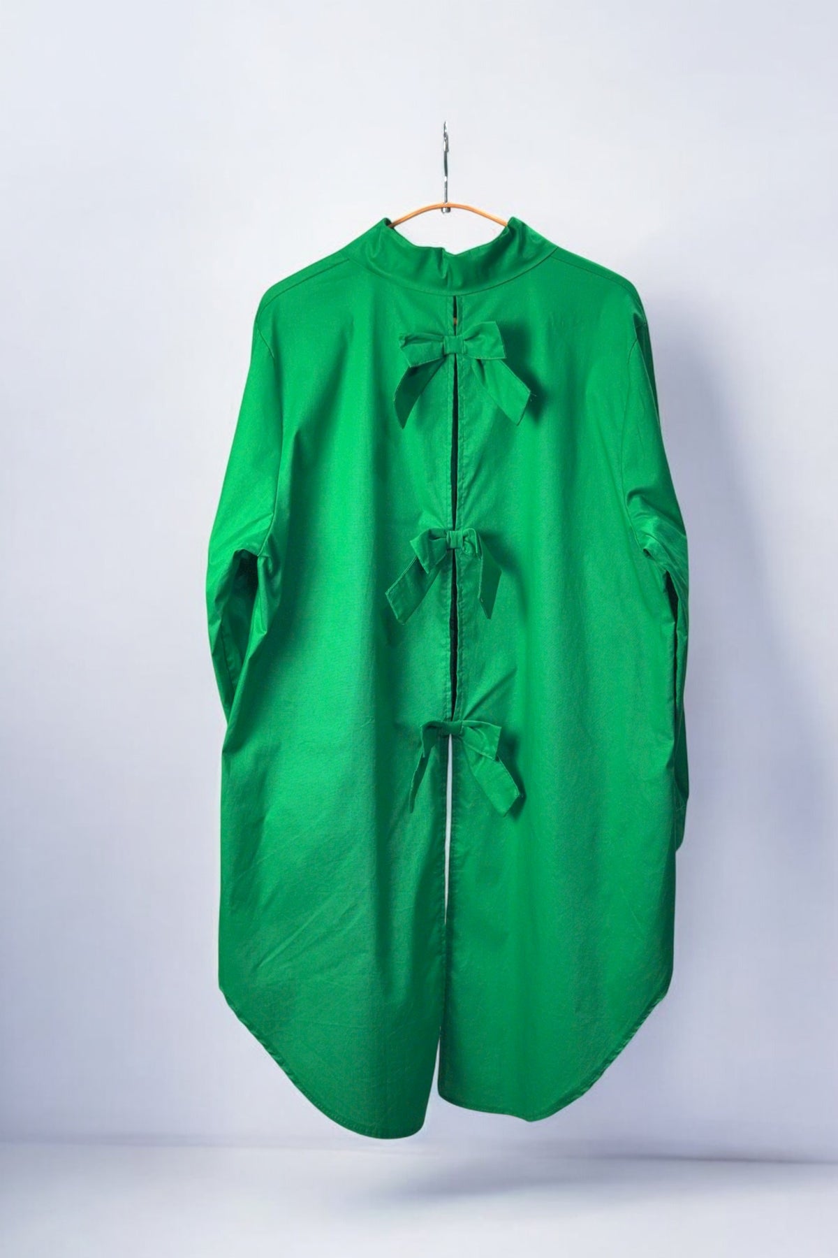 Cămașă asimetrică verde cu fundițe la spate, din material fluid și lejer.