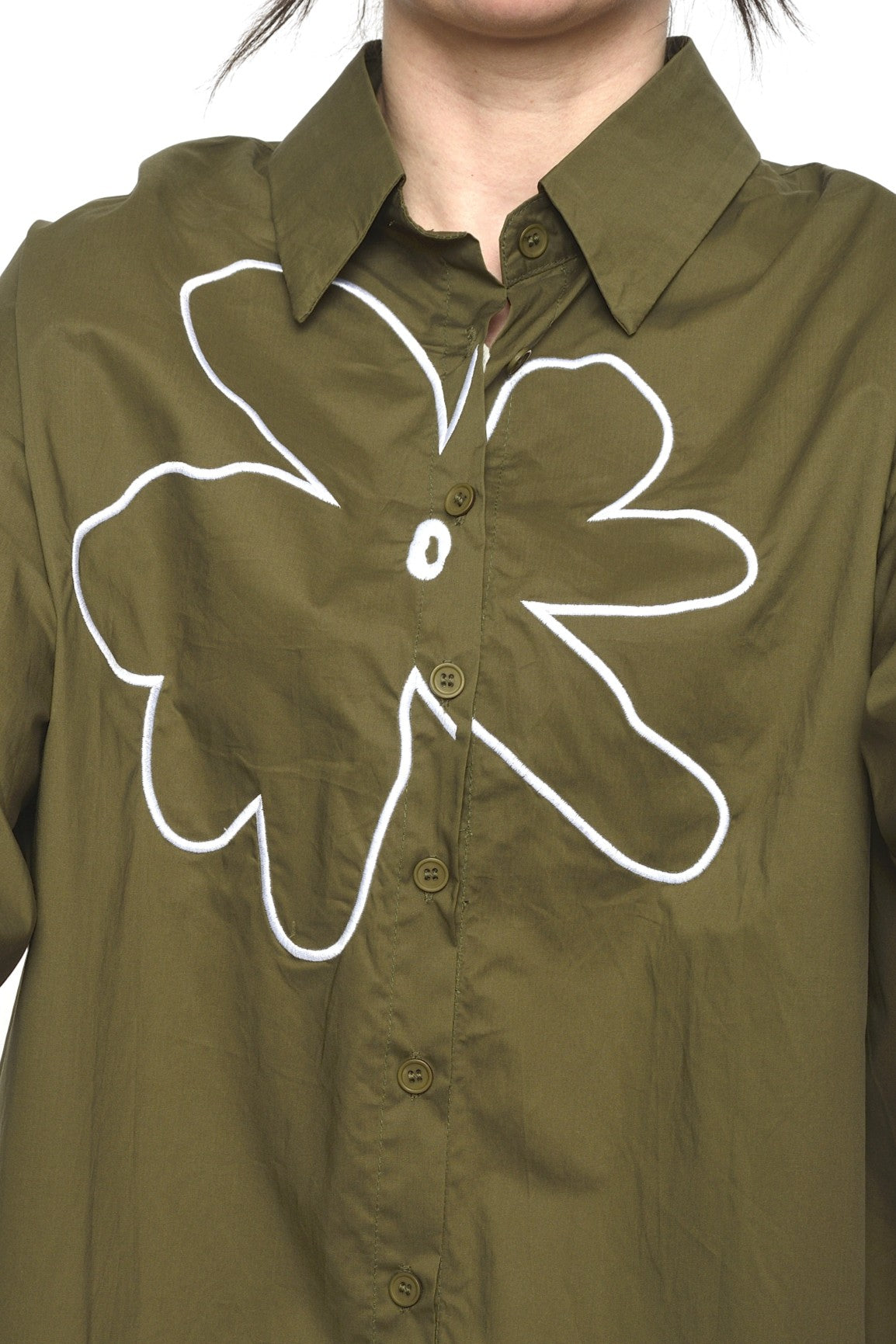 Detaliu broderie albă în formă de floare pe cămașă khaki din bumbac
