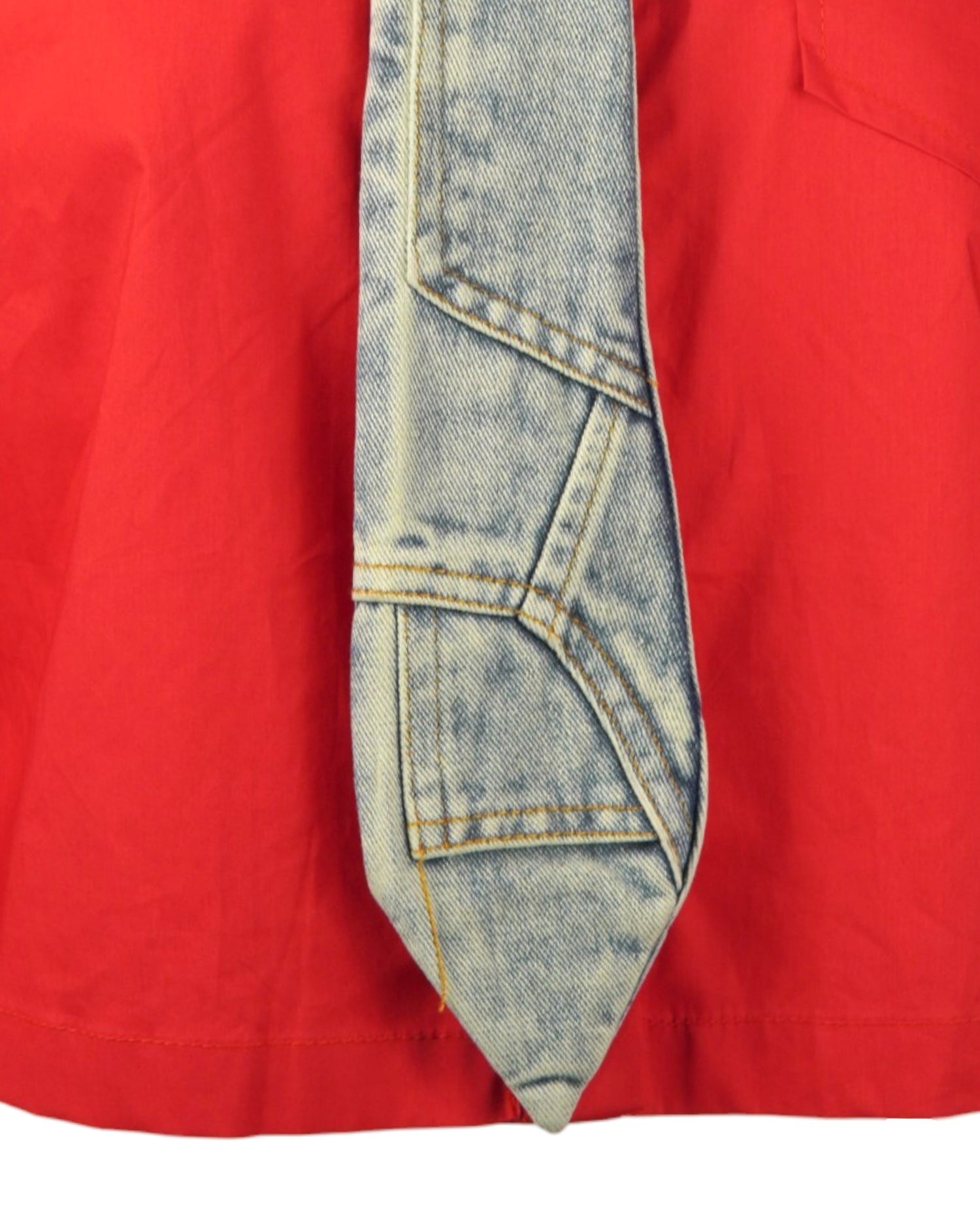 Cravată din denim atașată unei cămăși crop roșii, cu un design modern.