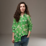 Cămașă verde din rayon cu imprimeu floral alb, purtată pe model, stil casual lejer cu mâneci lungi și nasturi albi

