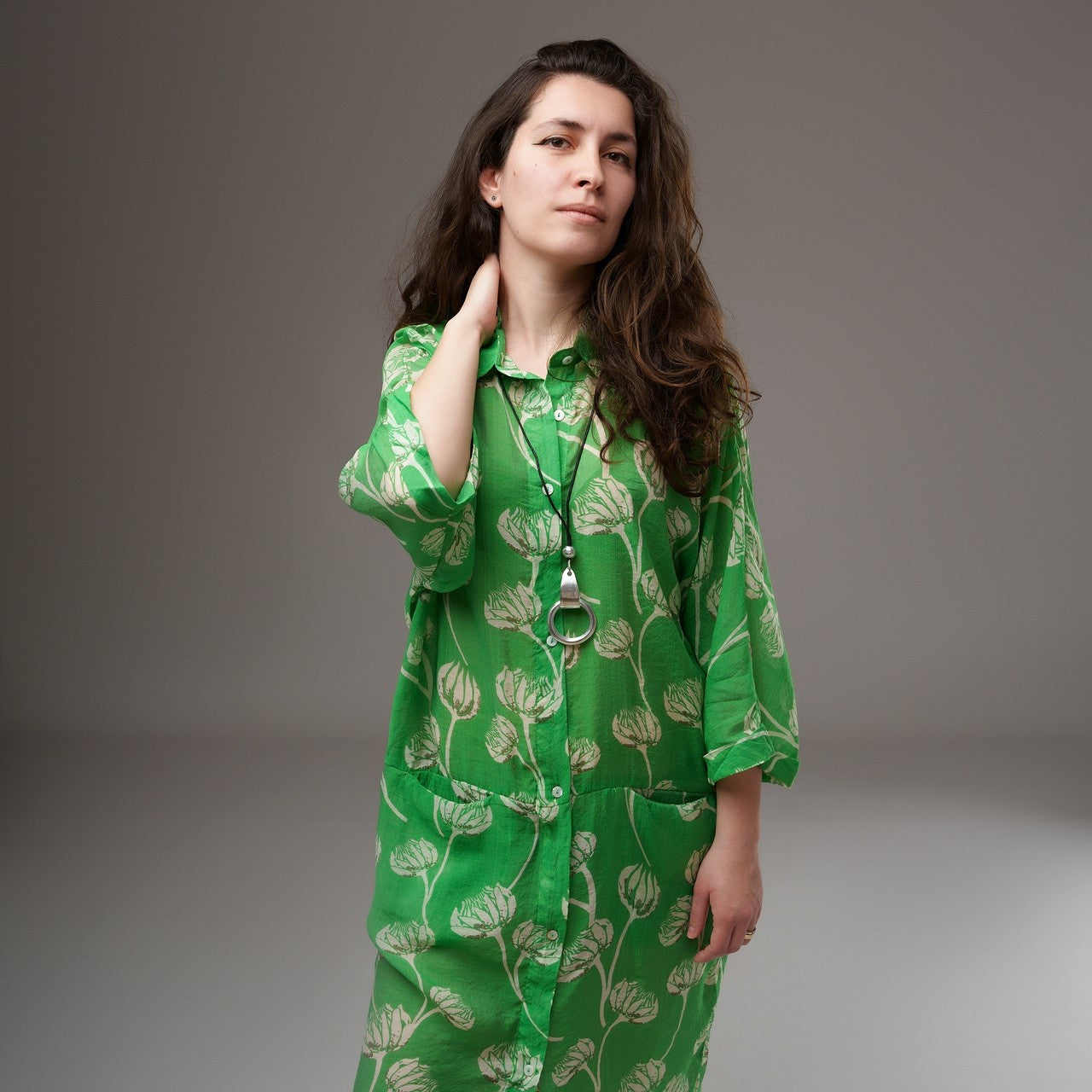 Detaliu guler și închidere frontală cu nasturi la o cămașă lungă verde din rayon cu imprimeu floral