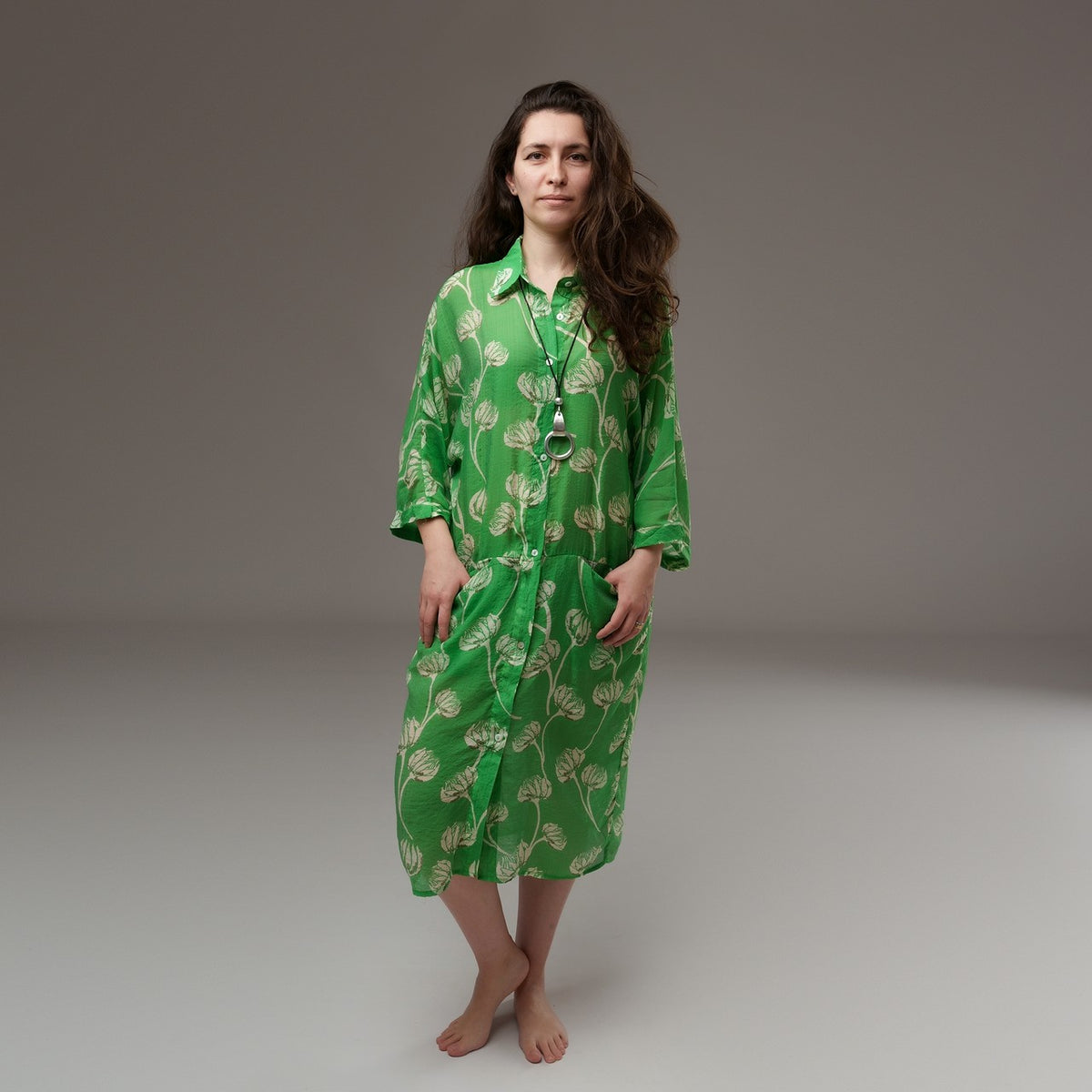 Cămașă lungă verde cu imprimeu floral bej, din rayon moale, purtată deschisă cu mânecile suflecate