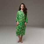 Cămașă lungă verde cu imprimeu floral bej, din rayon moale, purtată deschisă cu mânecile suflecate