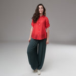 Cămașă roșie din rayon cu mânecă scurtă și nasturi, purtată cu pantaloni largi
