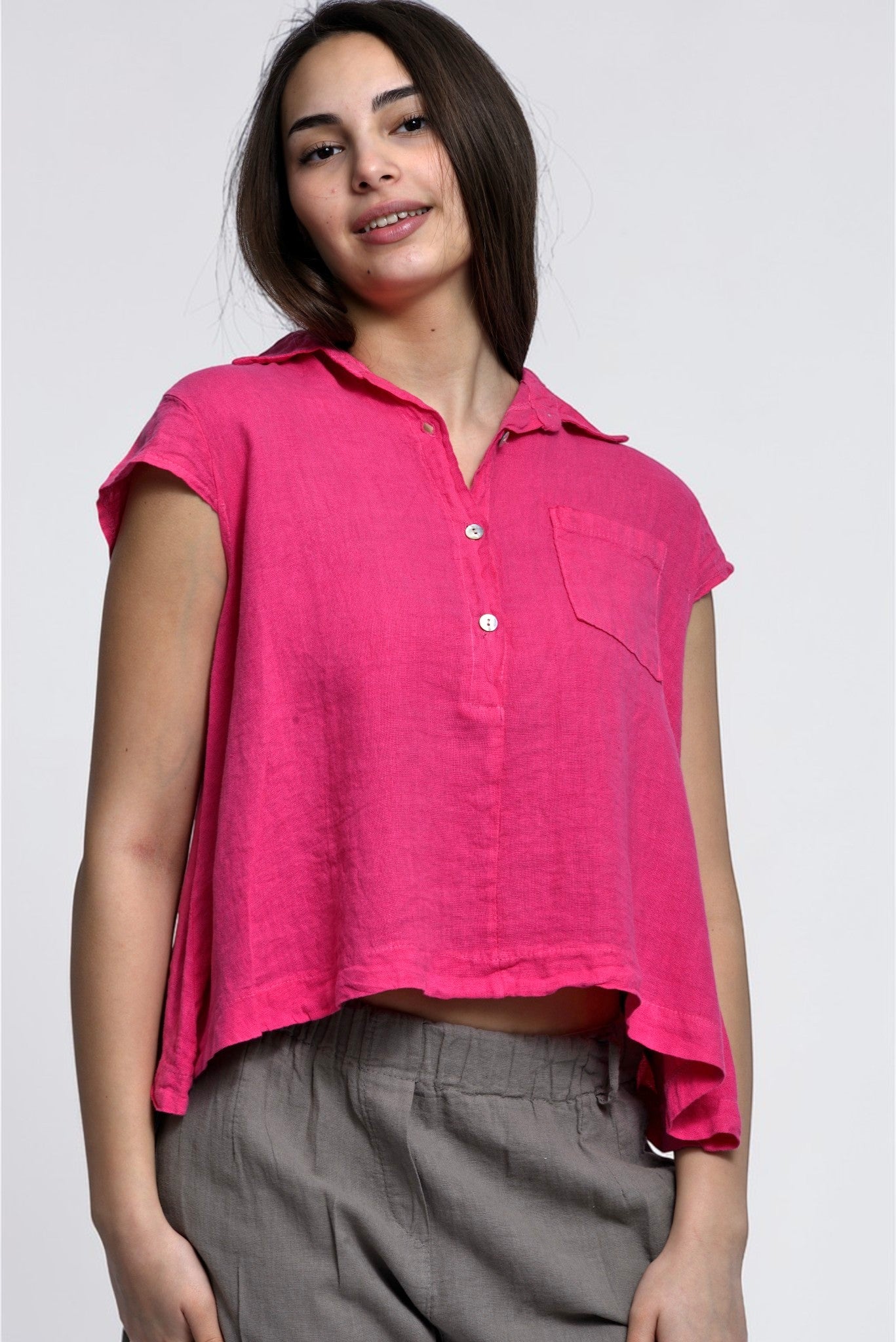 Model poartă cămașă scurtă din in roz, cu guler clasic și croială lejeră, ușor de integrat în ținute relaxate.