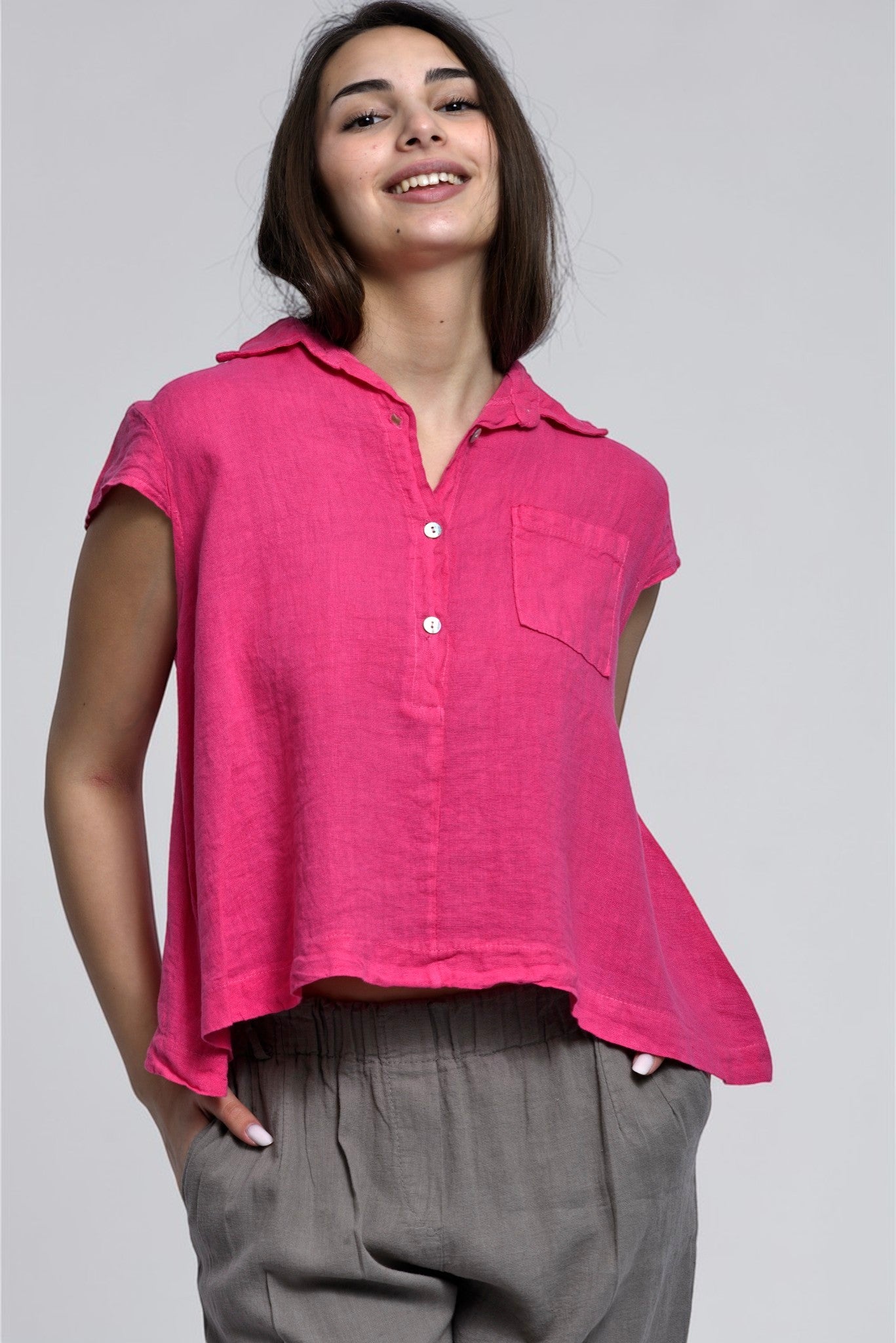 Detaliu cămașă din in roz cu nasturi și guler clasic, evidențiind textura naturală a materialului.