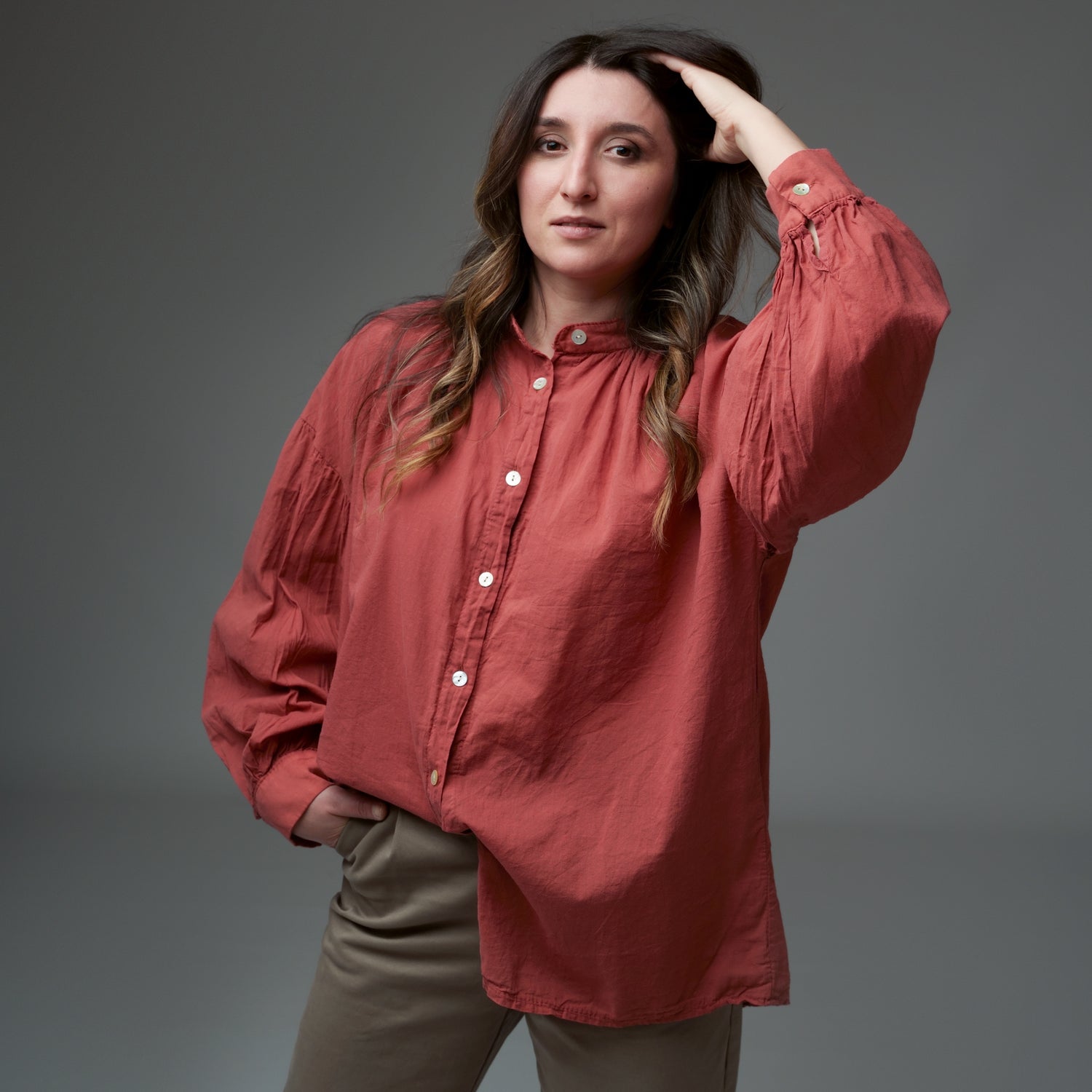 Model poartă tunica din bumbac culoare siena, cu croială lejeră și mâneci ample, alături de pantaloni bej. Modelul poartă mărimea S, modelul are 175 cm și 52 kg.