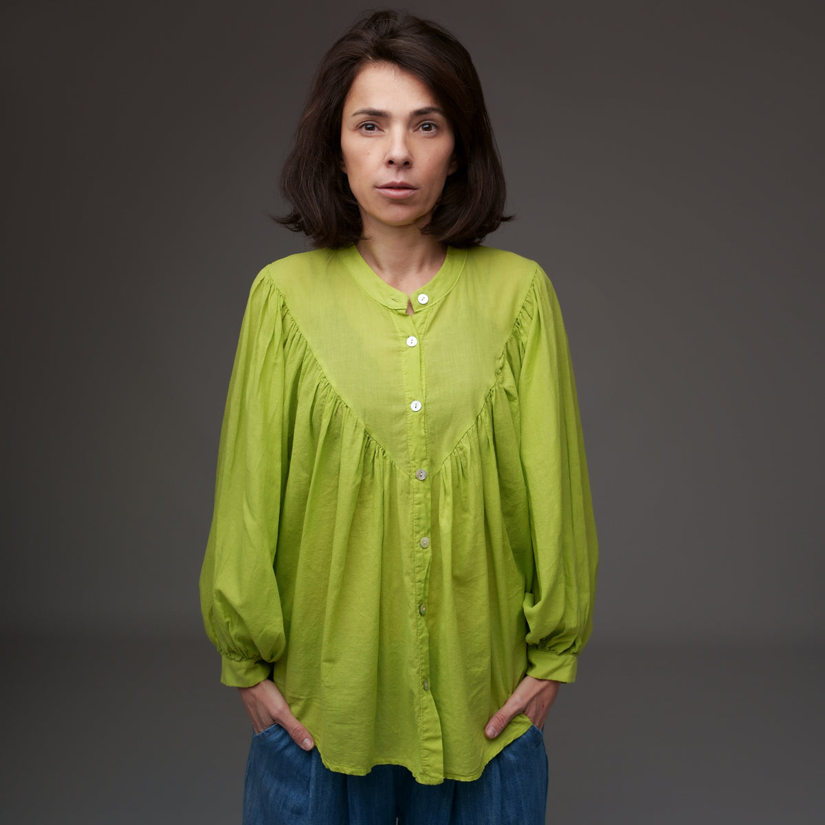 Cămașă verde fistic tip tunică, din bumbac, purtată cu blugi largi, cu nasturi și mâneci lungi.