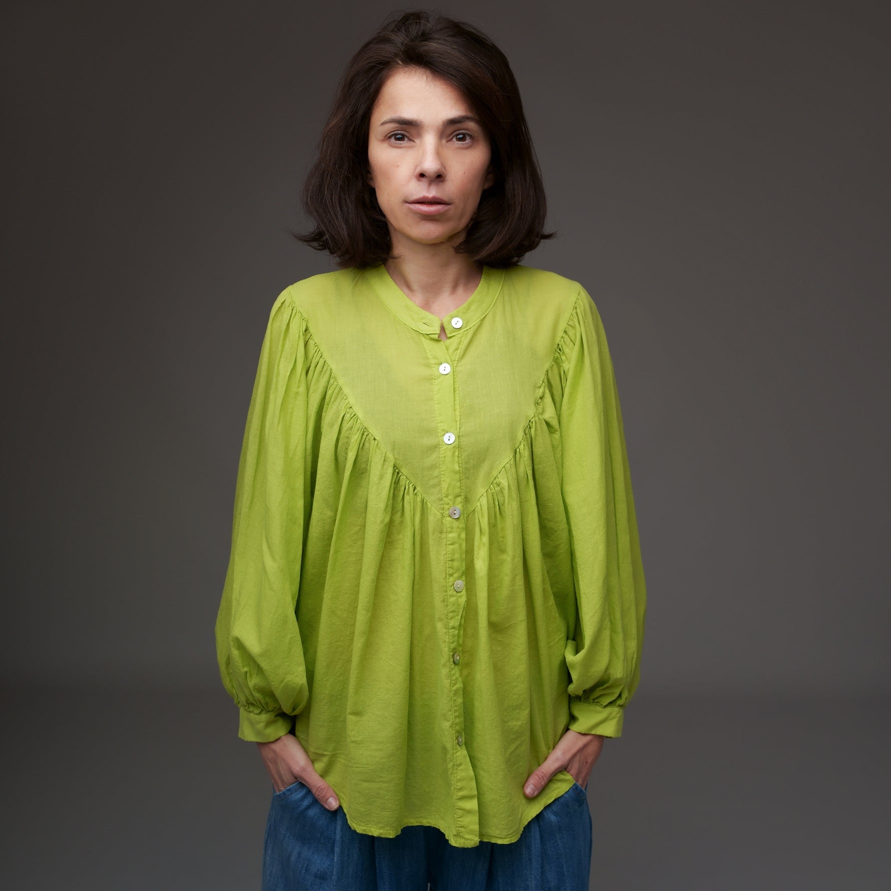 Cămașă verde fistic tip tunică, din bumbac, purtată cu blugi largi, cu nasturi și mâneci lungi.