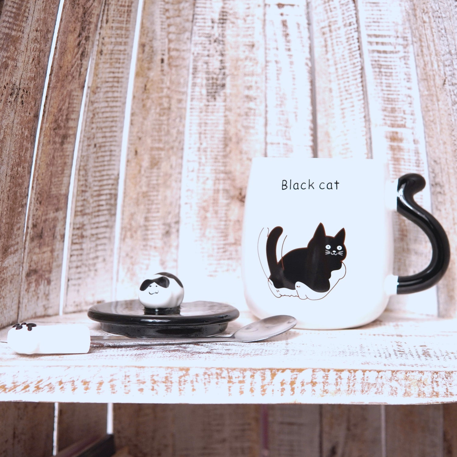 Cană albă din ceramică cu capac detașabil, linguriță decorată și imprimeu „Black Cat”.