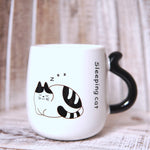Cană albă din ceramică cu mâner negru în formă de coadă de pisică și imprimeu „Sleeping Cat”, pisică dormind.