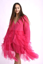 Cardigan roz cu franjuri, fotografiat lateral, scoțând în evidență textura bogată și croiala amplă.