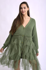 Cardigan verde cu franjuri, fotografiat din lateral, evidențiind textura și croiala lejeră.