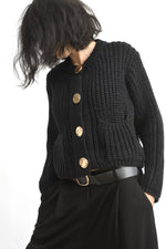 Cardigan tricotat scurt negru cu nasturi aurii, prezentat frontal pe model.