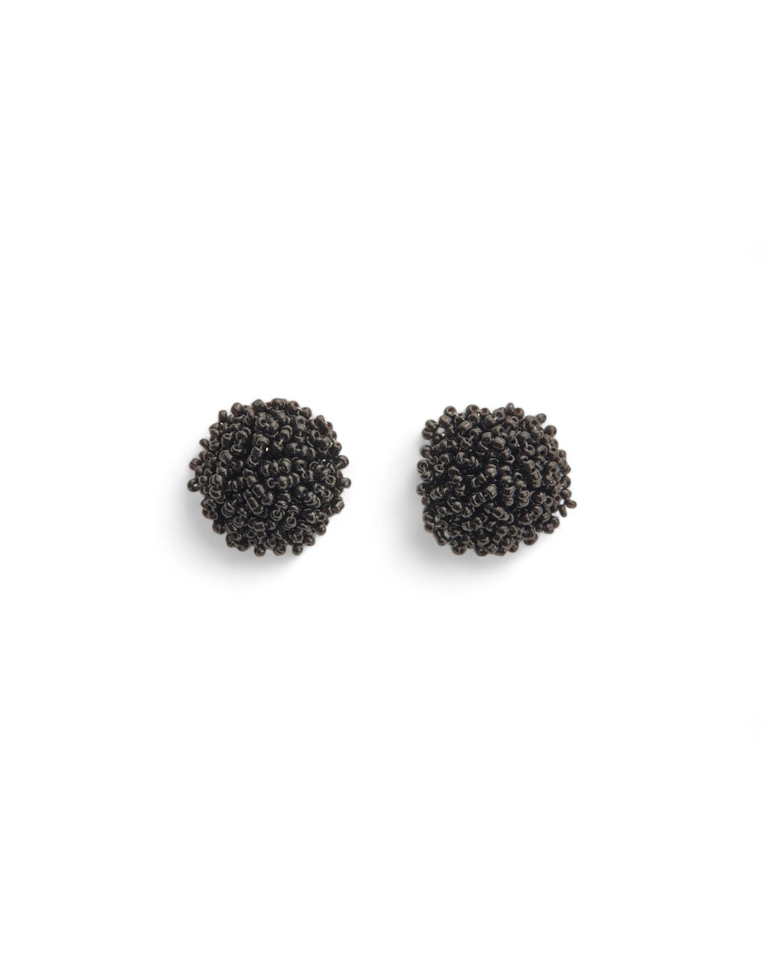 Cercei din margelute negre mici, oferind un look elegant și minimalist.