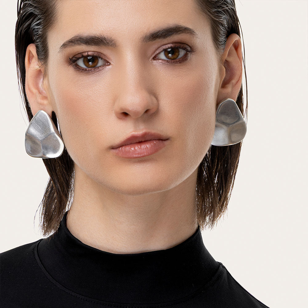 Cercei statement cu formă neregulată, inspirați din pietre naturale, realizați din aluminiu reciclat, fotografiați pe model.