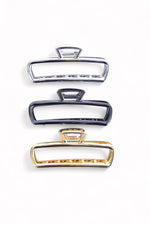 Set de clești metalici pentru păr în nuanțe aurii și argintii, ideali pentru prinderea fermă a părului.