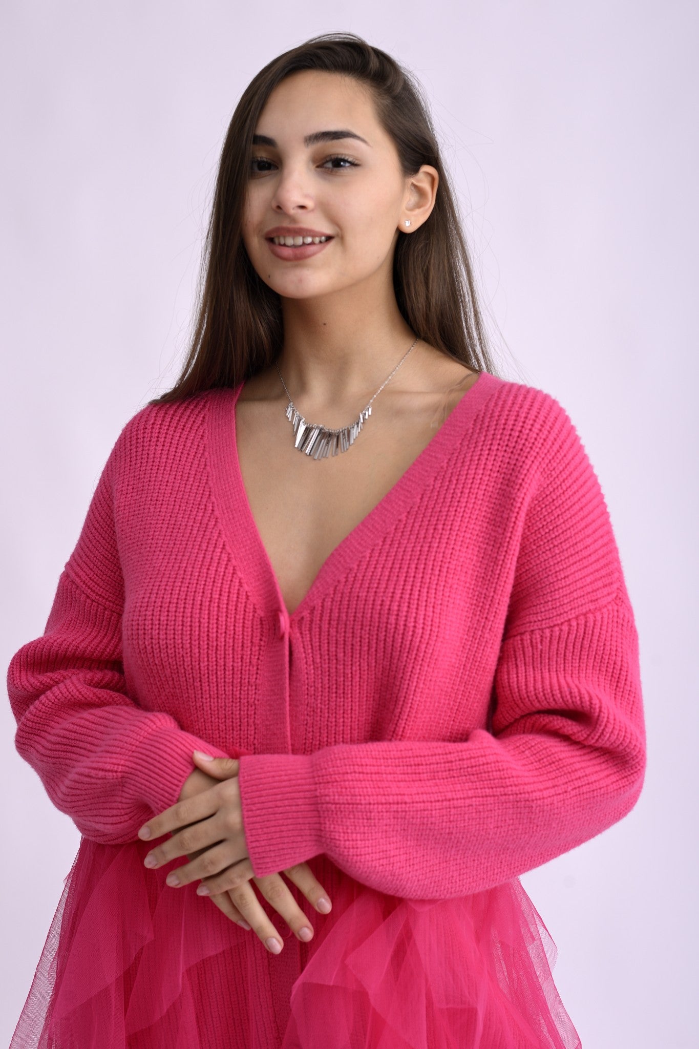 Detaliu al colierului argintiu cu pandantive subțiri și lucioase, evidențiind textura și finisajul strălucitor al metalului.