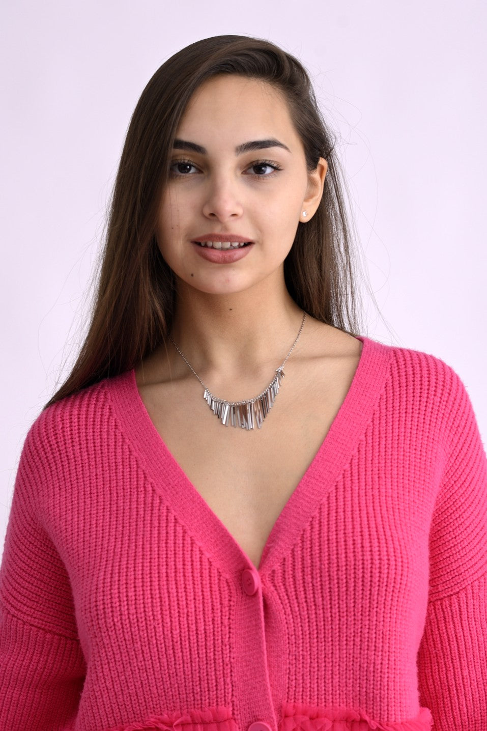 Colier argintiu cu pandantive metalice fine, purtat pe gât de model, detaliu prim-plan asupra bijuteriei.