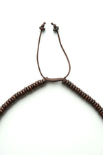 Detaliu al sistemului de prindere ajustabil al colierului cu discuri din lemn.