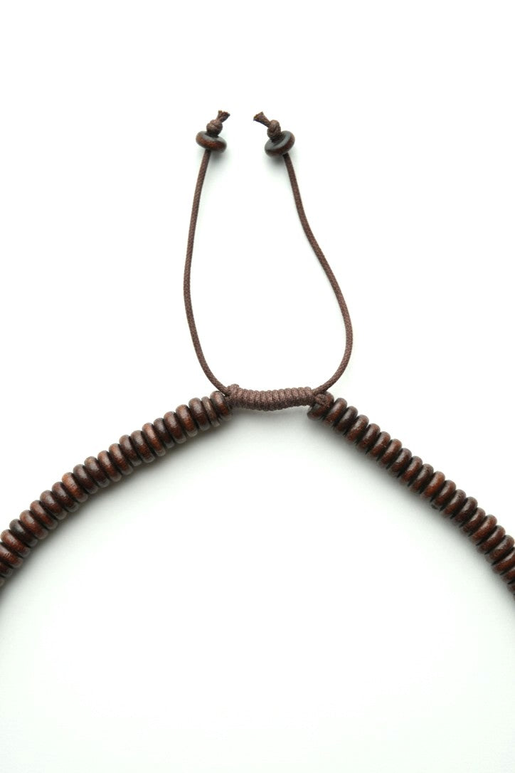 Detaliu al sistemului de prindere ajustabil al colierului cu discuri din lemn.