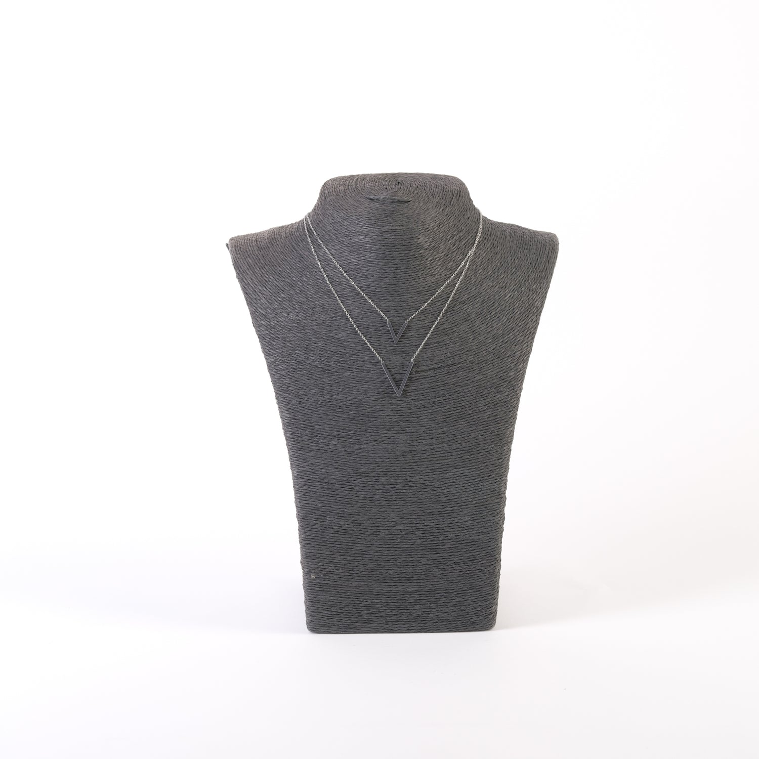 Colier argintiu cu design minimalist, expus pe suport negru, cu două pandantive V shape.