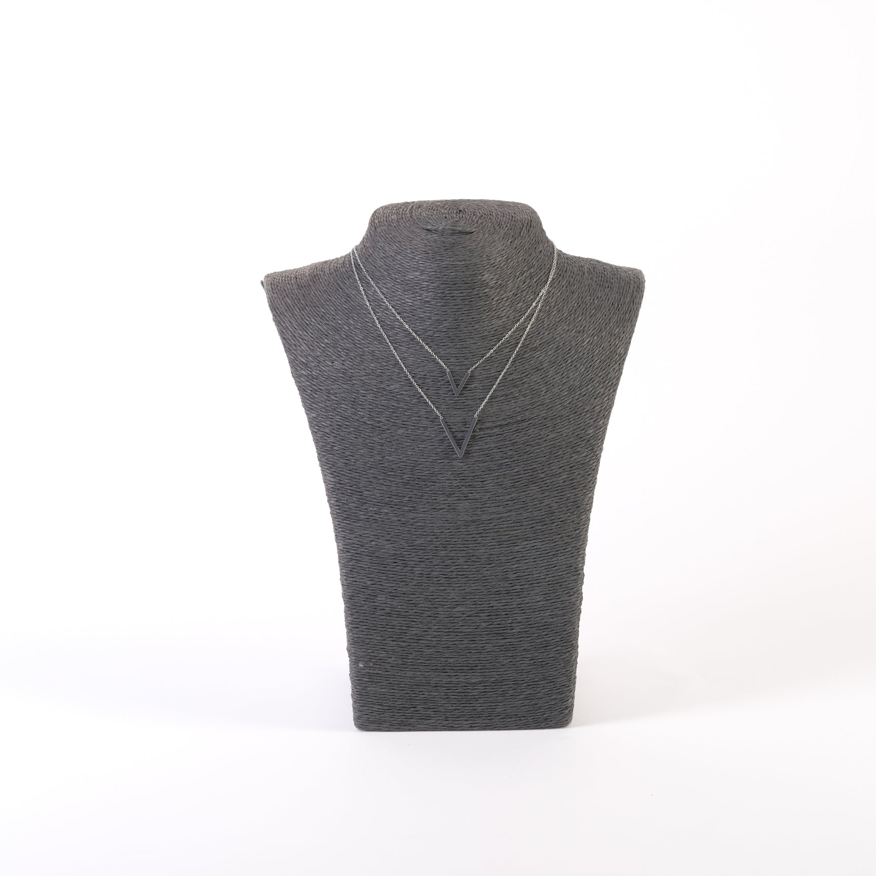 Colier argintiu cu design minimalist, expus pe suport negru, cu două pandantive V shape.