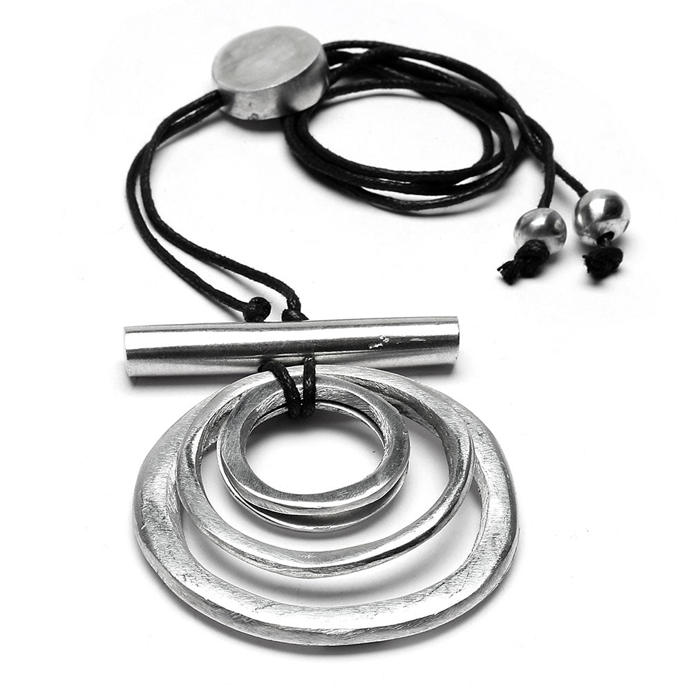 Colier pe șnur negru cu pandantiv din cercuri metalice din aluminiu 100% reciclat, fotografiat pe fundal alb.