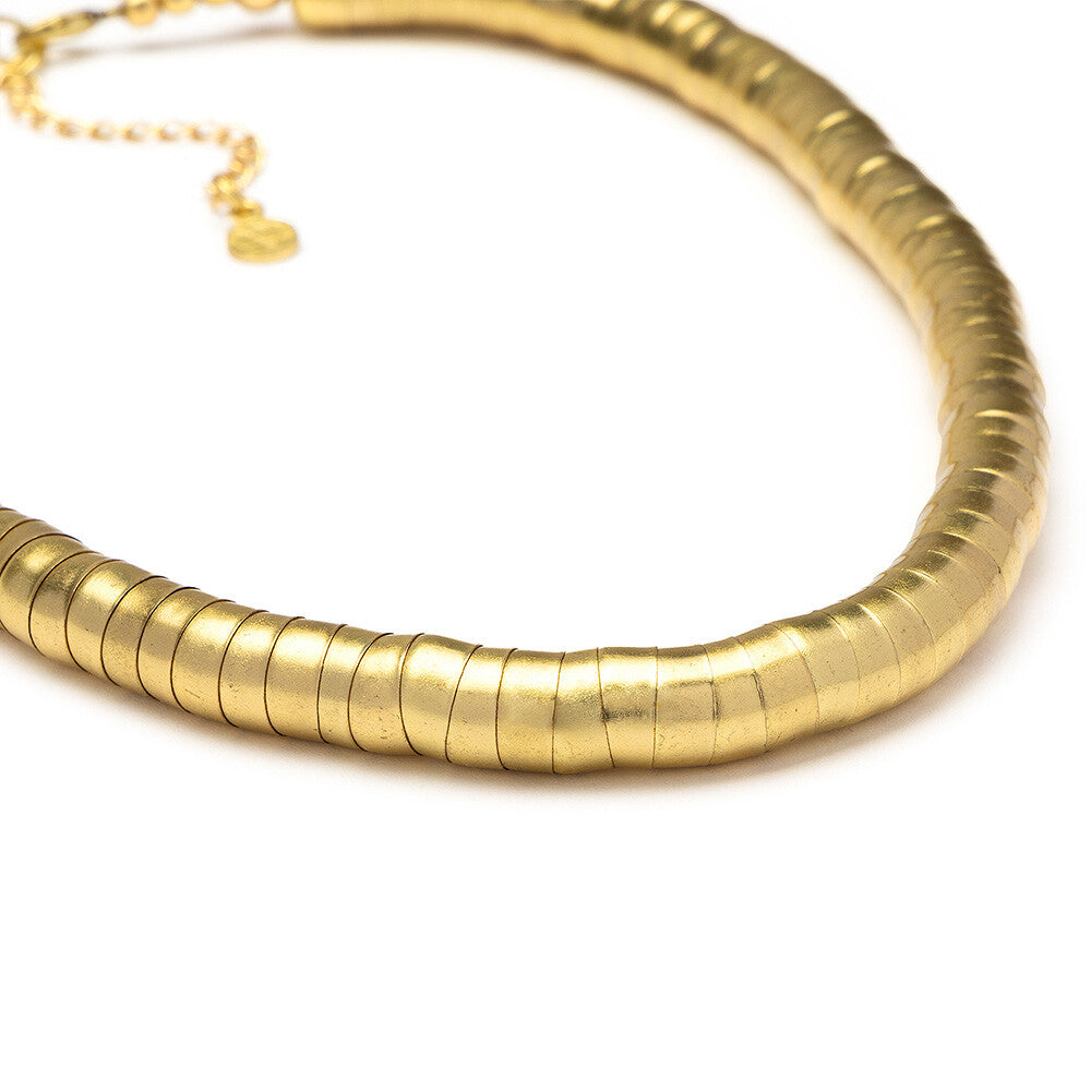 Detaliu al texturii snake a colierului din alamă reciclată, evidențiind forma rotundă și finisajul satinat auriu.