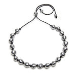 Colier reglabil pe șnur cu 20 de sfere din aluminiu reciclat, lucrat manual, purtat la baza gâtului de o femeie.