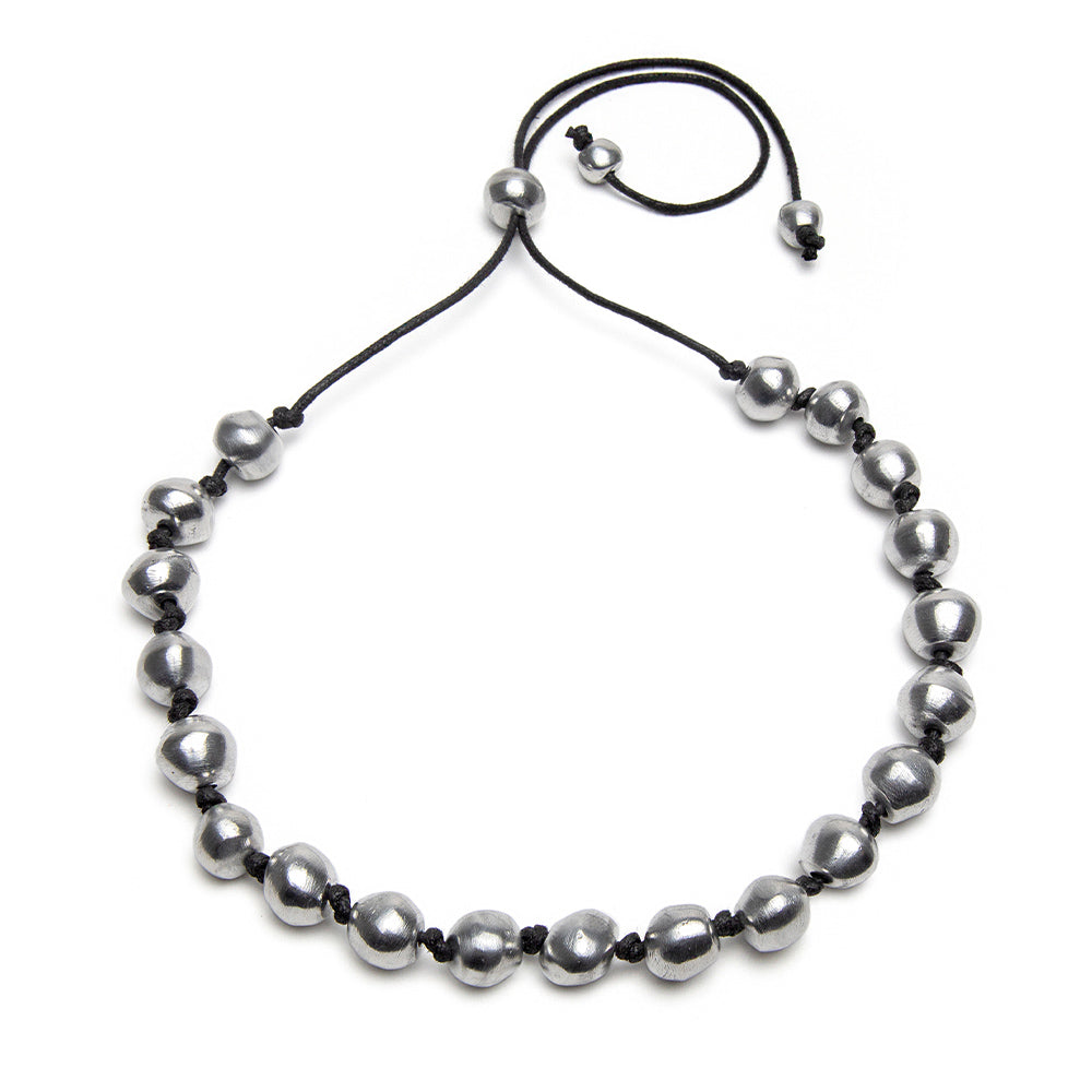 Colier reglabil pe șnur cu 20 de sfere din aluminiu reciclat, lucrat manual, purtat la baza gâtului de o femeie.